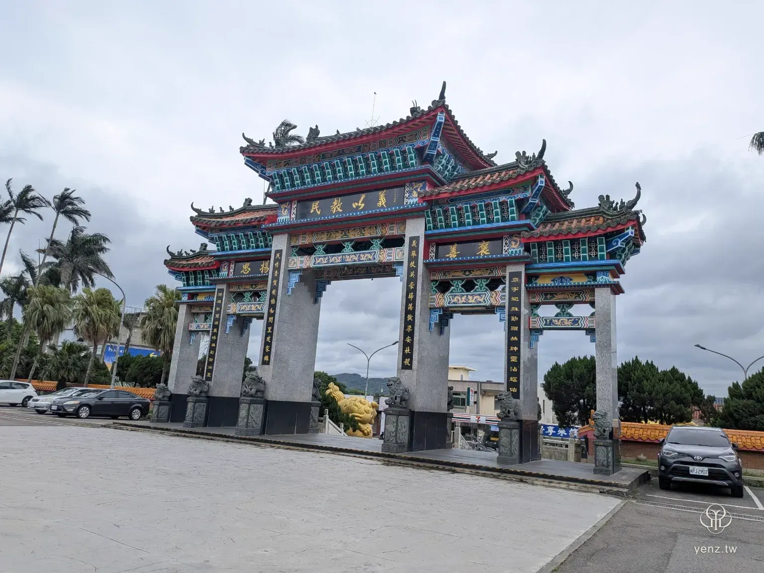 新竹新埔枋寮褒忠亭義民廟前的大型彩繪牌樓，前方是寬闊廟埕與停車空間。
