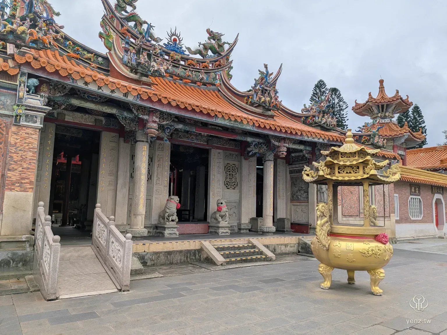 枋寮褒忠亭義民廟正殿外觀，前方有金色香爐，屋頂有橘瓦與彩色剪黏。