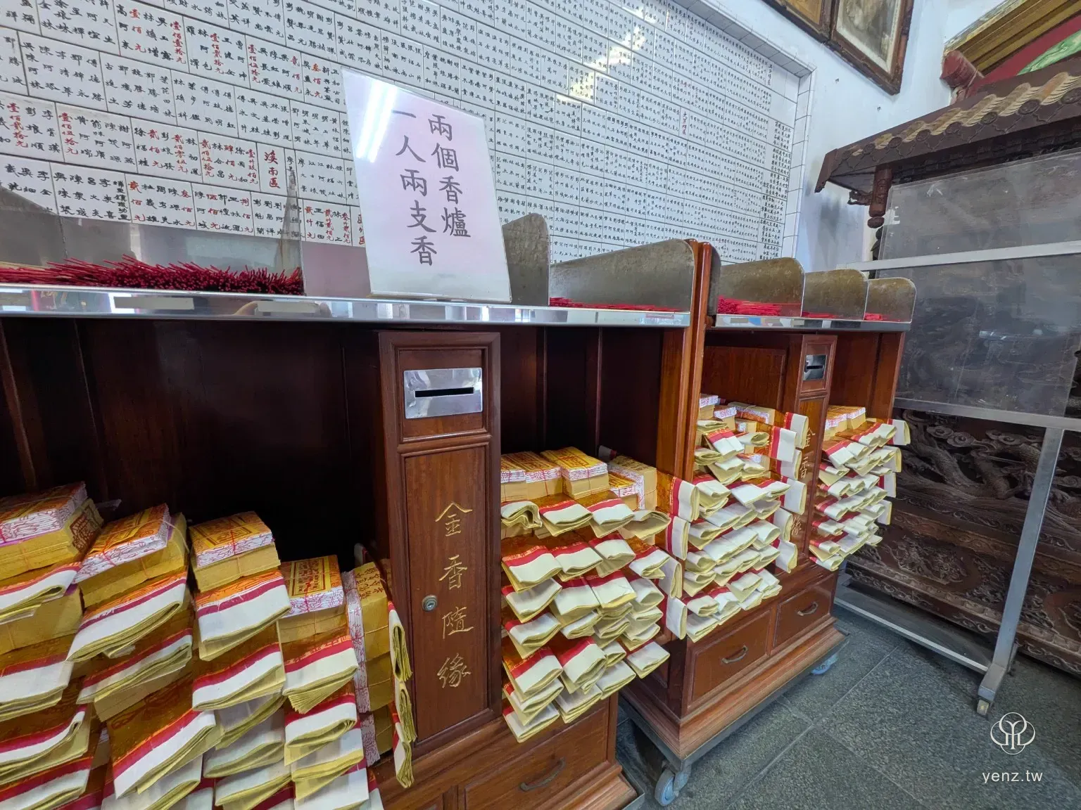 義民廟進香區的木櫃與桌面，上方有香、金紙與一張說明紙牌。