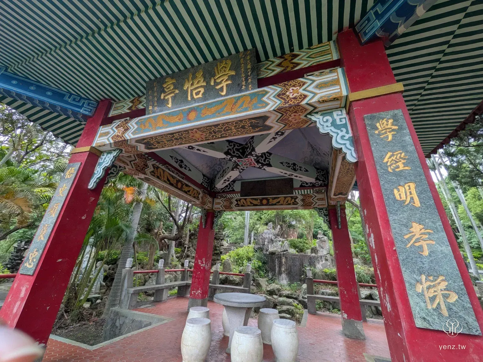 義民廟後花園的學悟亭，紅柱上有金字楹聯，亭內有石桌石凳。