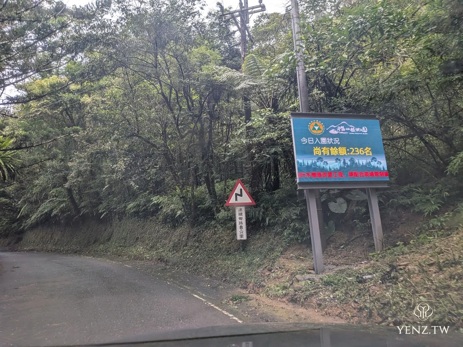 山路旁電子看板顯示「今日入園狀況 尚有餘額 236 名」，旁有連續彎路警示牌。