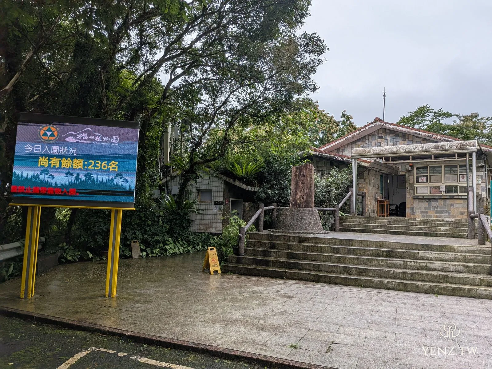 石造的入園管制站，門口有餘額電子看板與木樁標誌。