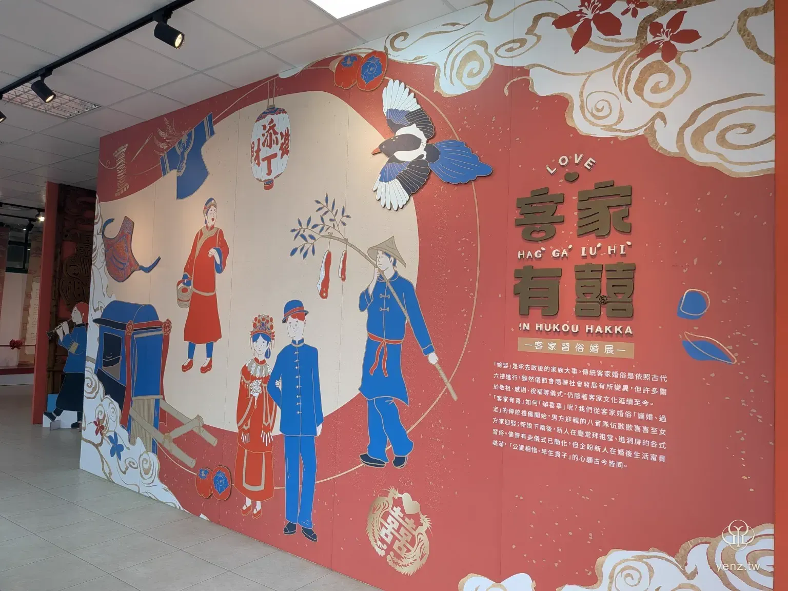 客家有囍婚慶文化展牆，牆面有客家婚禮人物插畫、喜字、燈籠與展覽說明。