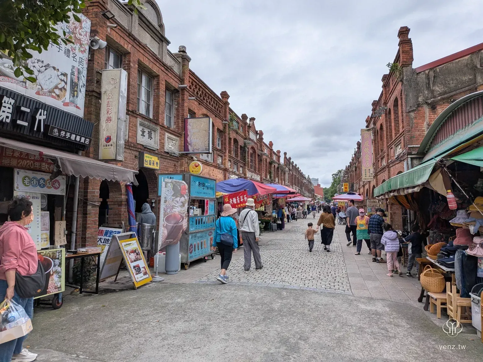湖口老街街景，兩側紅磚立面商店與攤位，街上有遊客行走。