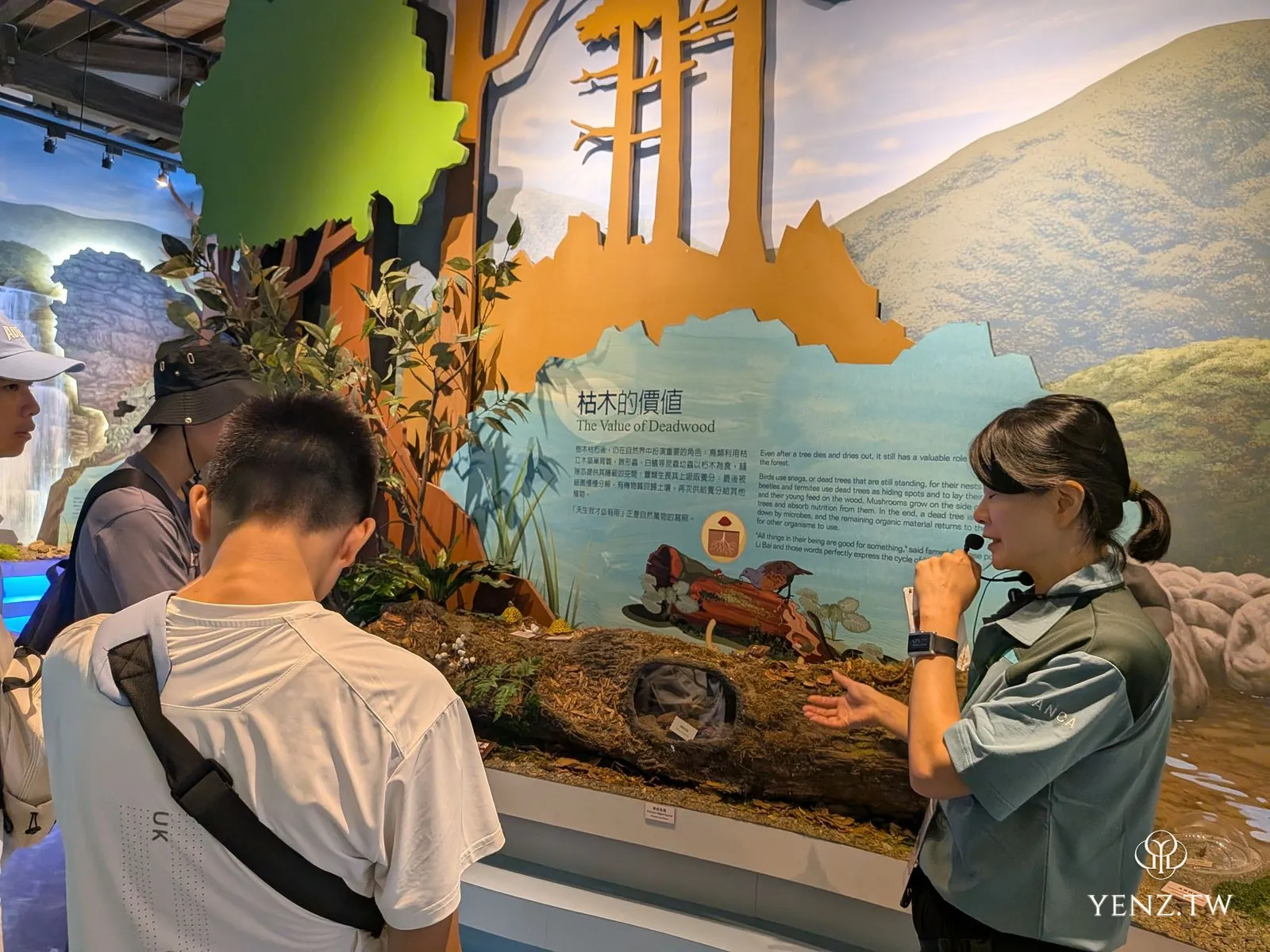 溪流館內，導覽員向遊客講解「枯木的價值」展示。