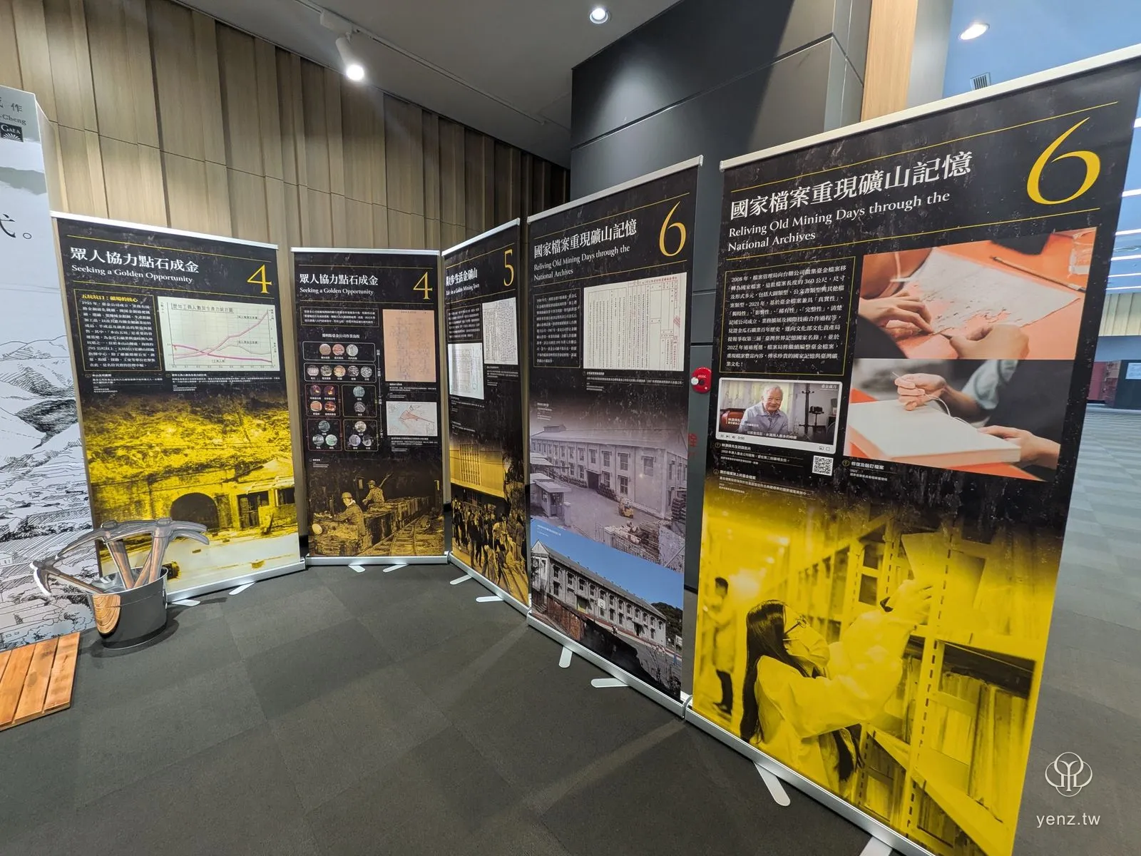 「臺金歲月」特展的易拉展架單元板，黑黃色調的礦業主題。