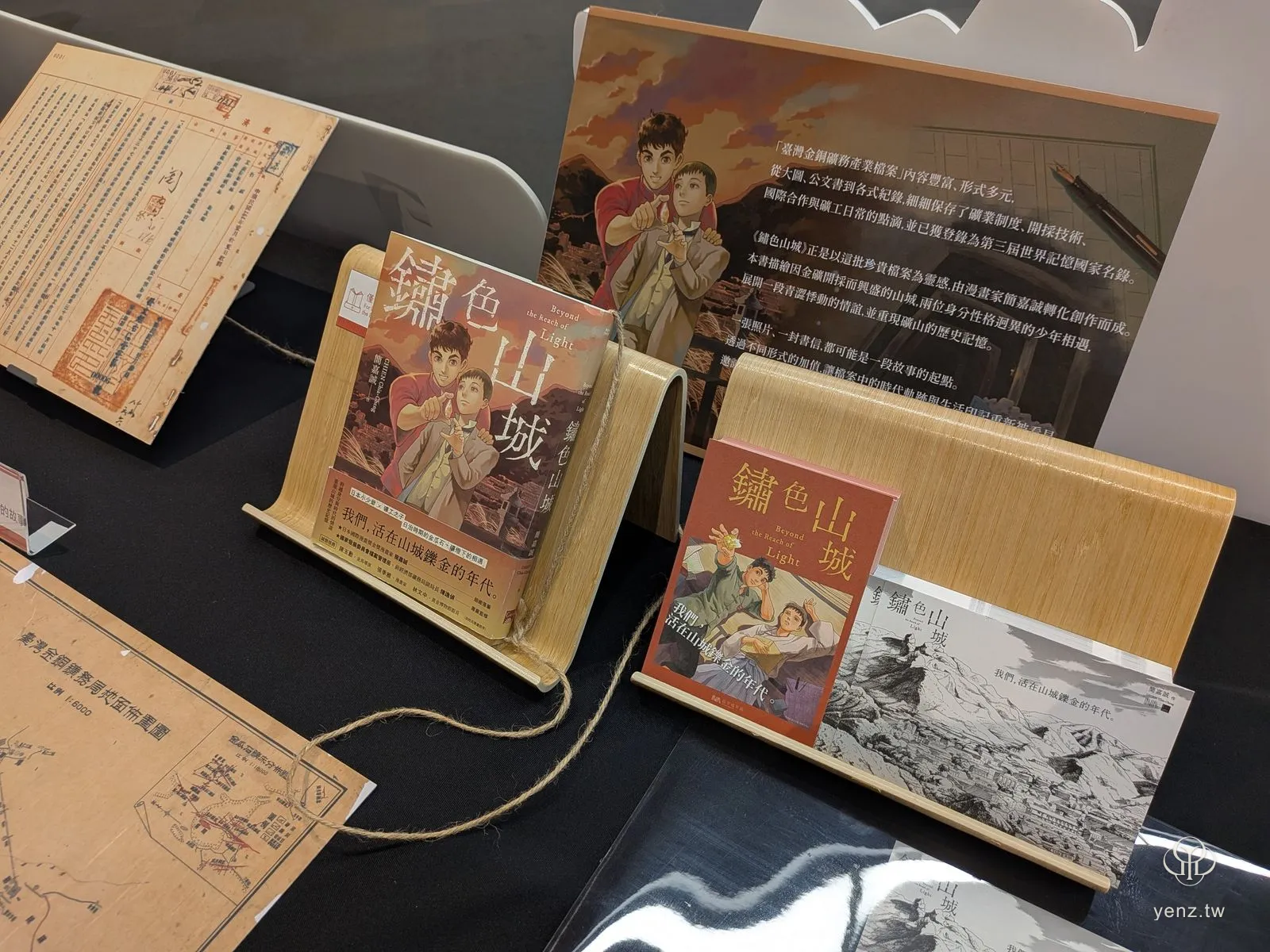 《鏽色山城》漫畫書與真實檔案並置的展示桌。