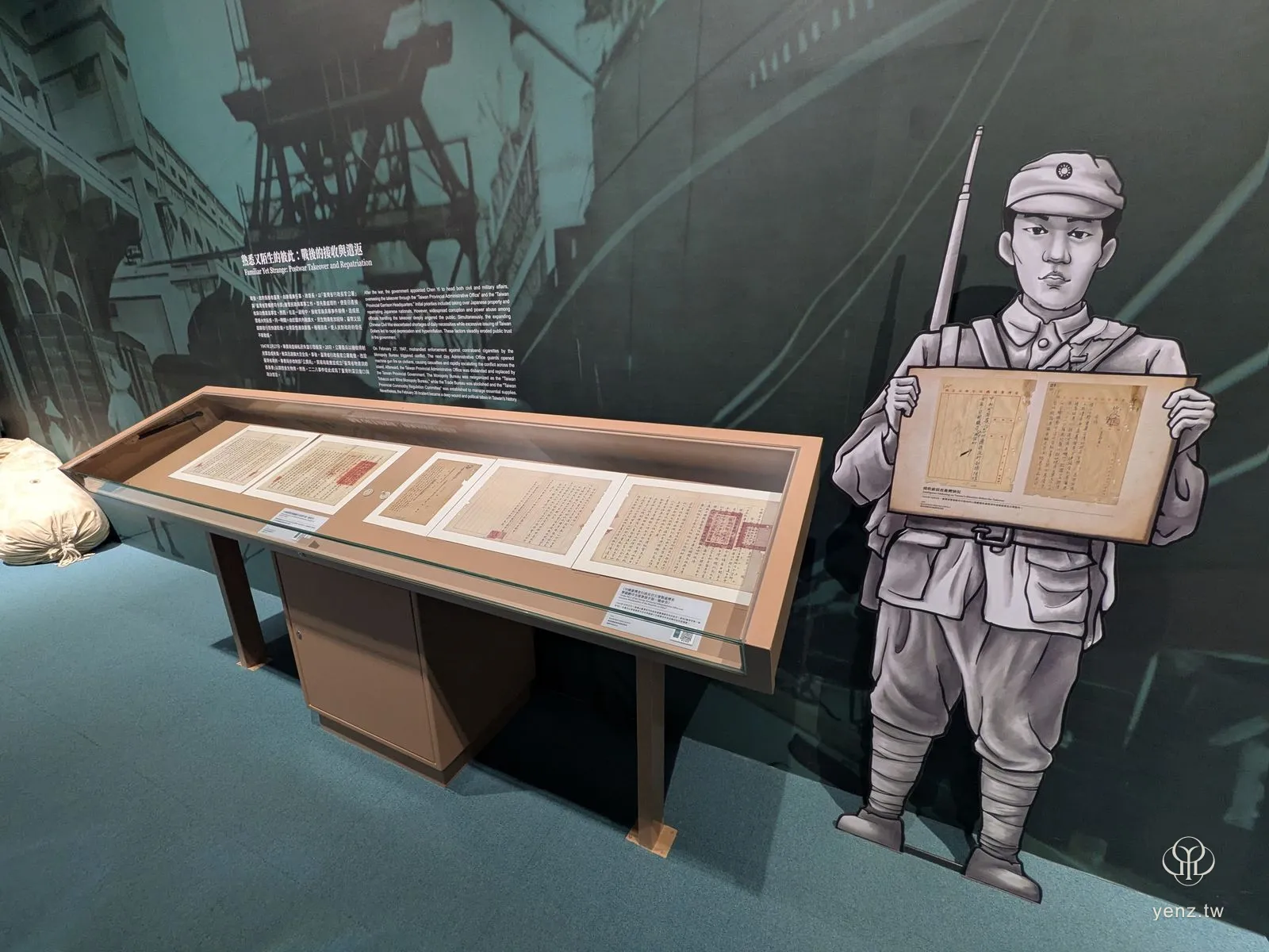 「戰後的接收與遣返」展區，軍人插畫立牌捧著檔案影像。
