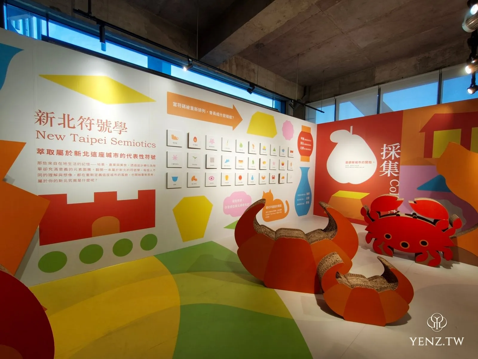 「新北符號學」展區，牆上排列著城市符號方格，前方是瓦楞紙做的螃蟹與牛角造型坐具。