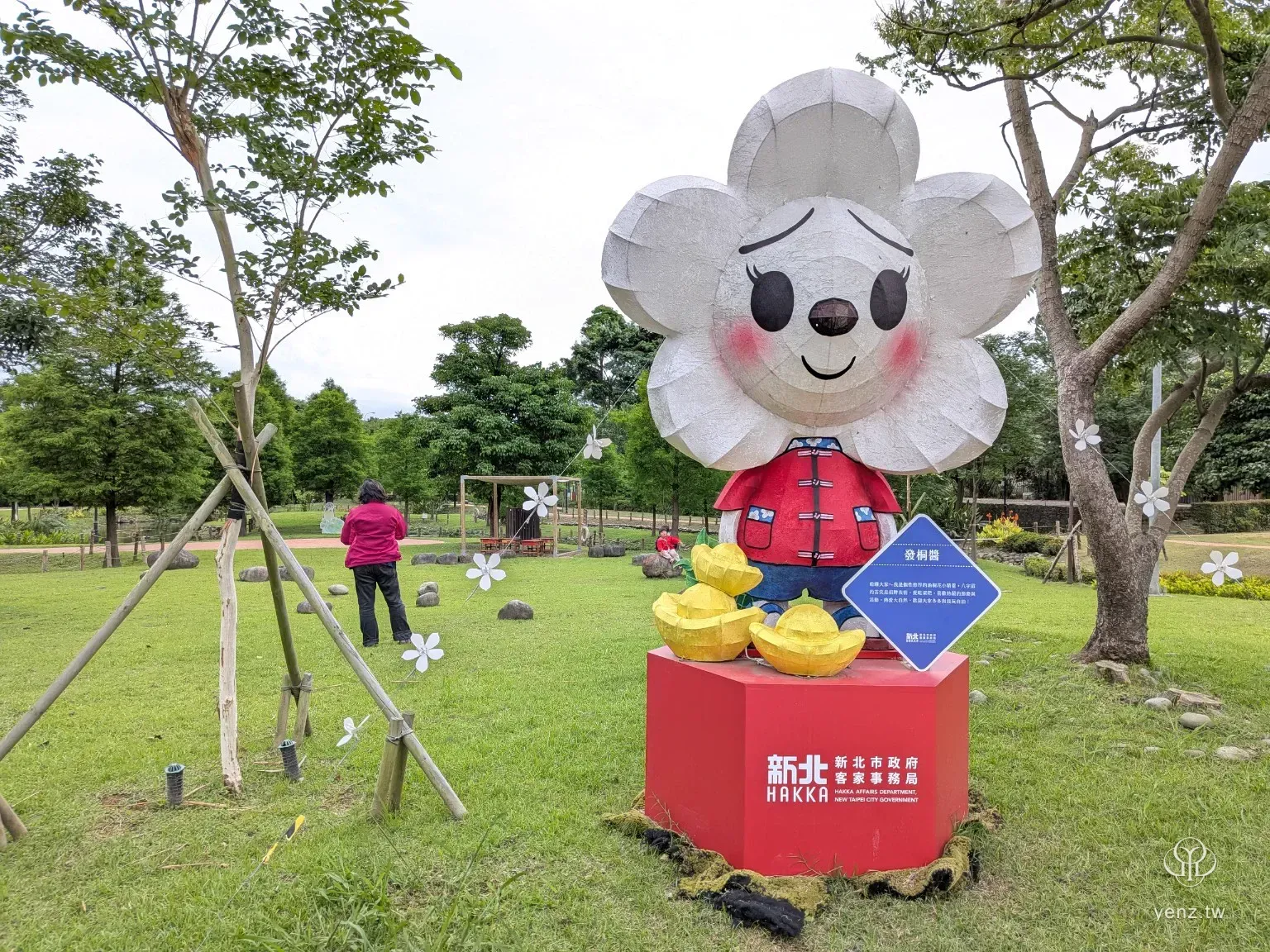 新北客家吉祥物發桐醬，穿著客家服飾站在紅色底座上。